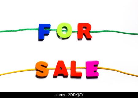For sale word text written from wooden colorful painted abc letters with holes, strung on a lace, shopping buying, selling concept Stock Photo
