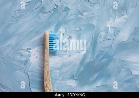 Wooden bamboo toothbrush, on a blue background Stock Photo