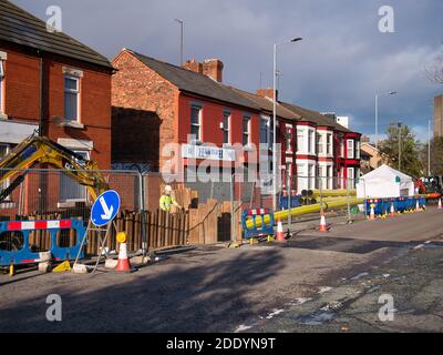 Traffic is diverted around an excavated area of road as replacement gas mains pipeline is laid. The new pipe is of a yellow, flexible plastic type. Stock Photo