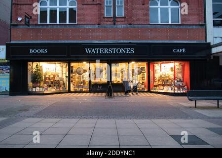 A single older person reads a sign outside a closed branch of the UK bookseller Waterstones on a declining high street in the north west UK. Stock Photo