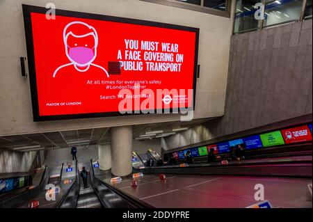 London, UK. 26th Nov, 2020. The underground remains reasonably busy as the second Coronavirus lockdown nears its end. Those who do travel mostly wear masks after they become mandatory on public transport and the warning signs make the message clear. Credit: Guy Bell/Alamy Live News Stock Photo