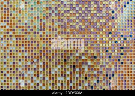 Square gold and orange tile mosiac on the wall with green, turquoise, yellow, blue colors on it. Stock Photo