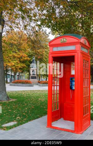 British red telephone box in Victoria Square, with Queen Victoria statue in the background. Christchurch, New Zealand. Stock Photo