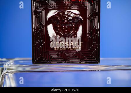 Viersen, Germany - May 9. 2020: Close up of isolated Versace eros flame men perfume flacon in on glass, blue background