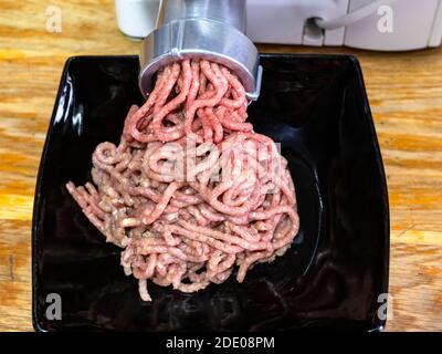 Meat-grinder, grinding fresh meat into minced meat Stock Photo - Alamy