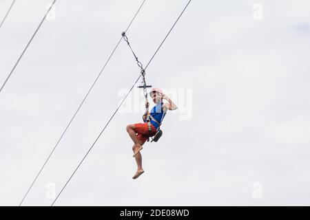 A Filipino man zip lining in Bicol, Philippines Stock Photo