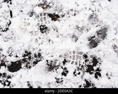 top view of footprints in the first snow on surface of outdoor playground on cold autumn day Stock Photo