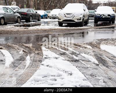 the melting first snow on car parking area on cold autumn day Stock Photo