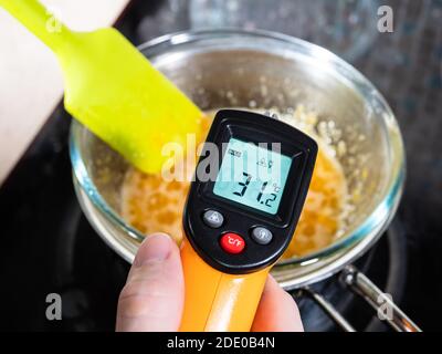 https://l450v.alamy.com/450v/2de0b4n/cooking-sweet-sponge-cake-at-home-measuring-temperature-of-mixture-in-glass-bowl-on-water-bath-by-infrared-thermometer-on-stove-at-home-kitchen-2de0b4n.jpg