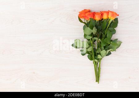 Bunch of orange roses lying on wooden background Stock Photo