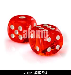 Red acrylic transparent dice for games. Two gambling translucent dices isolated on white background, macro close up high resolution. Stock Photo