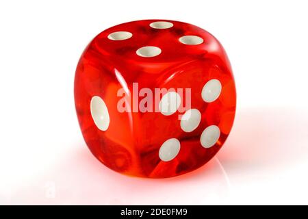 Red acrylic transparent dice for games. Gambling translucent dices on white background, macro close up high resolution. Stock Photo