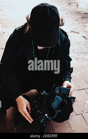 Haired guy from shooting team corrects focus on camera Stock Photo