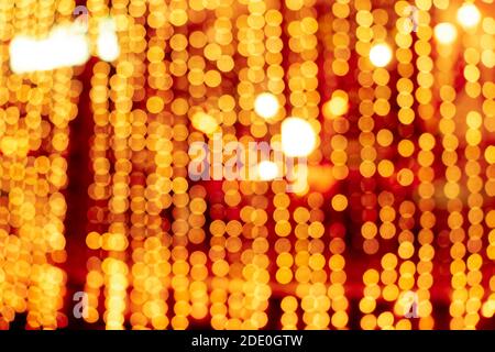 Cozy evening in the festive city. Blurred image of shop windows  decorated with light garlands for Christmas and New Year celebration. Shining window Stock Photo
