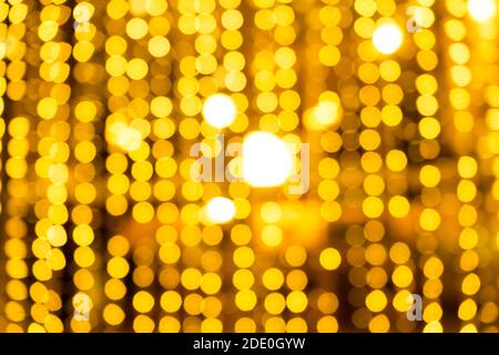 Cozy evening in the festive city. Blurred image of shop windows  decorated with light garlands for Christmas and New Year celebration. Shining window Stock Photo