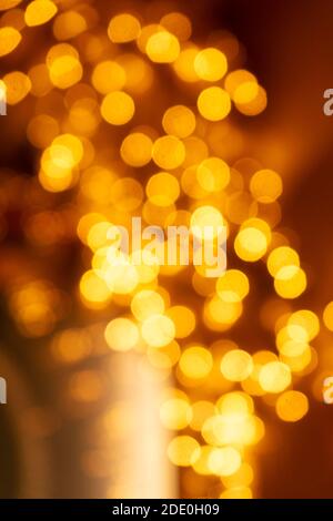 Cozy evening in the festive city. Blurred image of shop windows  decorated with light garlands for Christmas and New Year celebration. Shining window Stock Photo