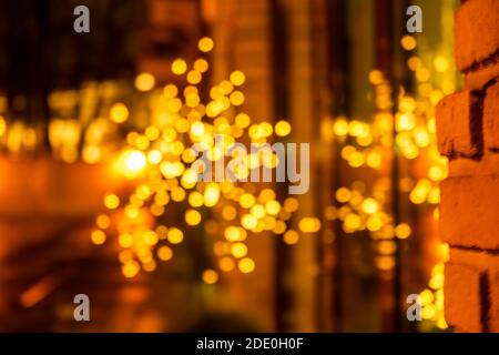 Cozy evening in the festive city. Blurred image of shop windows  decorated with light garlands for Christmas and New Year celebration. Shining window Stock Photo