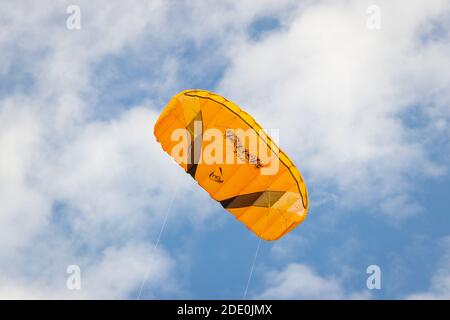large yellow stunt kite in blue sky Stock Photo