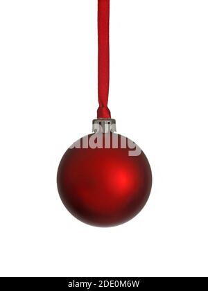 A single, red, standard Christmas tree ornament hangs from a red ribbon in a vertical view. Stock Photo