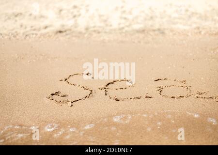Handwritten Sea Word on the Sand Coast. Wonderful words on beach sand. Love idea concept. Stock Photo