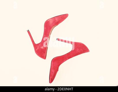 Footwear with thin high heels, stiletto shoes, top view. Pair of fashionable high heeled pump shoes. Shoes made out of red suede on white background, isolated. Luxury footwear concept. Stock Photo