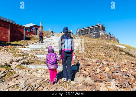 SNEZKA, GIANT MOUNTAINS - OCTOBER 12, 2019: Tourists hiking in Giant Mountains, Czech: Krkonose. View from Snezka - the highest mountain. Czech Republic and Poland. Stock Photo