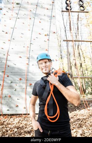 Portrait of a happy man well equipped with protective climbing equipment at amusement park outdoors Stock Photo