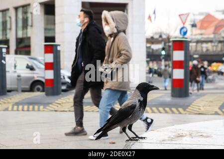 Berlin, Germany. 27th Nov, 2020. Pedestrians wearing face masks walk past a bird in Berlin, capital of Germany, on Nov. 27, 2020. Germany's COVID-19 caseload has topped 1 million after 22,806 new infections were reported within one day, the Robert Koch Institute (RKI) announced on Friday. Credit: Shan Yuqi/Xinhua/Alamy Live News Stock Photo