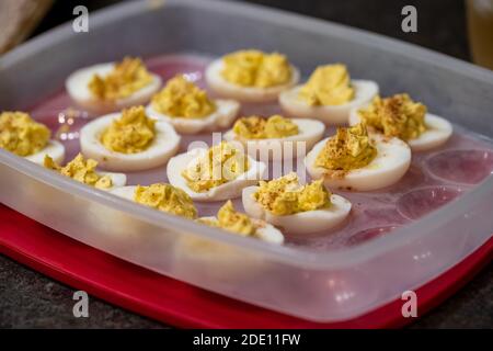 Deviled eggs, prepared and placed in a plastic container for serving at a party. Selective focus Stock Photo