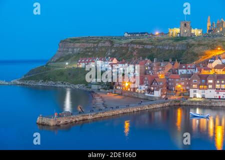 View of St. Mary's Church and Whitby Abbey from across River Esk at dusk, Whitby, Yorkshire, England, United Kingdom, Europe