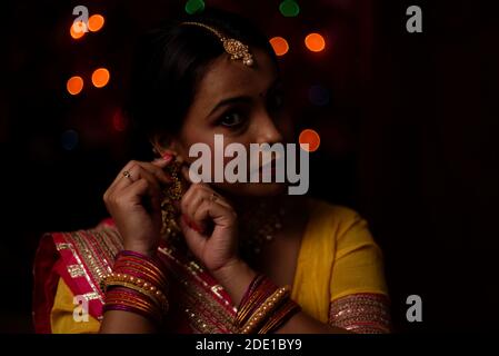 Portrait of an Indian Bengali beautiful brunette woman in front of the colorful light bokeh background in the evening of Diwali. Indian lifestyle Stock Photo