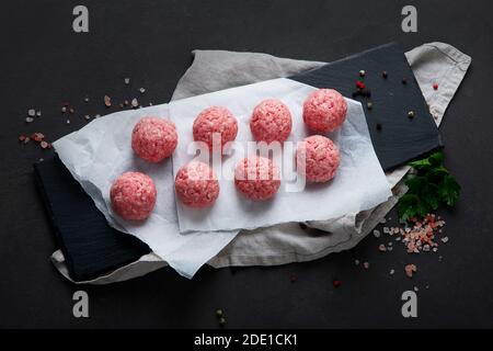 Fresh raw meatballs with herbs. Top view, copy space Stock Photo