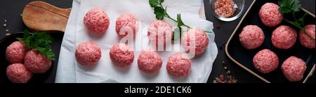 Fresh raw meatballs with herbs. Top view Stock Photo