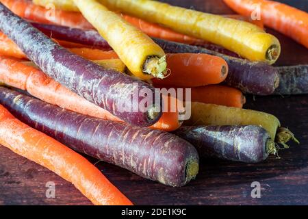 Baby rainbow carrots on a wooden background Stock Photo