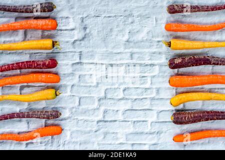 Baby rainbow carrots on a white background with copy space - overhead view Stock Photo