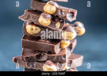 Pile chocolate with nuts on the gray background, close up Stock Photo