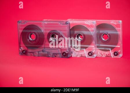 Three plastic audio tape cassettes on red background Stock Photo