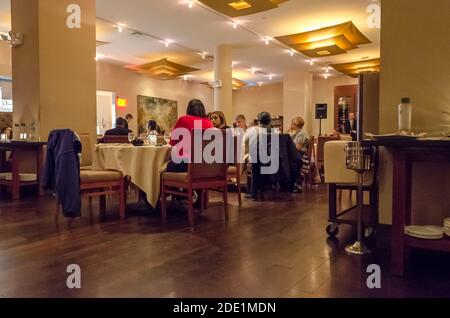 Group of People Eating and Preparing to Celebrate New Year's Eve in an Indian Restaurant. Elegant Dining Interior. Manhattan, New York City, USA Stock Photo