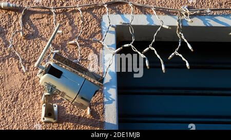 Solar security camera installed on pink wall with Christmas decoration Stock Photo
