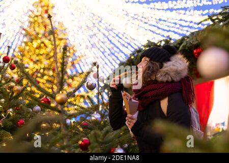 Lady eats handmade Christmas cookies at the Christmas market in Moscow Stock Photo