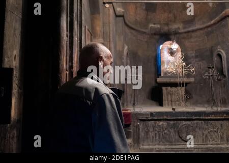 An Armenian man stands inside St. Gevorg Chapel small basilica replete with a semicircular apse at the site in which the Armenians’ patron saint, Gregory the Illuminator, was imprisoned 1,700 years ago by King Trdat III (or Tiridates) for preaching Christianity at the complex of the ancient monastery of Khor Virab located in the Ararat plain in Armenia, near the closed border with Turkey Stock Photo
