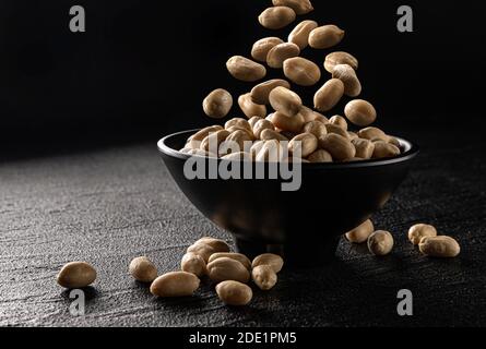 Falling peanut on black background with copy space Stock Photo