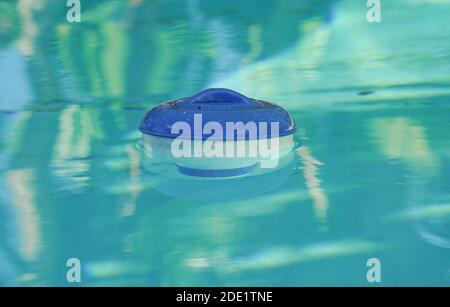 Split underwater view of a chlorine floater dispenser in a pool Stock Photo