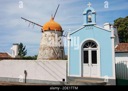 Red windmill and church in azores island Stock Photo