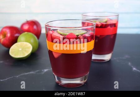 Closeup Chilled Red Wine Sangria on the Table with Blurry Fresh Fruits in the Background Stock Photo