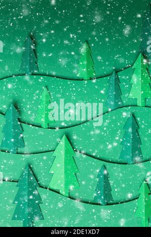 3D pop out Christmas trees paper artwork in green background with snowflakes. Christmas tree paper cutting design card. Top view. Flat lay Stock Photo