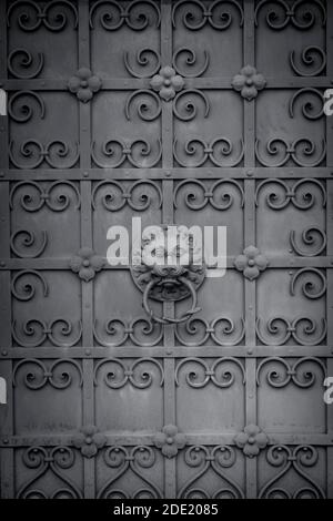 Detail of an ornate door knocker on a cast iron door in Munich, Germany, with copy space Stock Photo