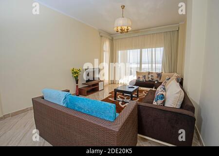 Living room lounge area in luxury apartment show home showing interior design decor furnishing with balcony and sea view Stock Photo