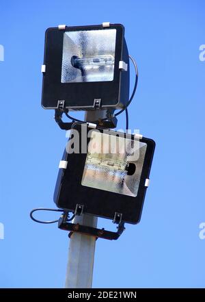 two halogen spotlights set on a mat on blue sky background. Stock Photo