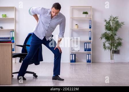 Handsome male employee doing exercises in the office Stock Photo